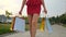 Close-up beautiful legs of young shopping girl woman female in red dress with bags packages walking outdoors street city