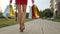 Close-up beautiful legs of young shopping woman female in red dress with bags packages walking outdoors street city