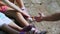 Close-up, a beautiful orange mountain butterfly sits on a child`s foot in sandals. male hand is trying to take, catch a