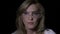 Close up of a beautiful scientist blonde woman wearing goggle glasses on a dark background -