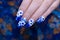 Close up beautiful shiny dark blue glitter gel nail art ombre design painting 3D white cute flower