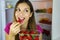 Close up of beautiful smiling girl near the fridge eating strawb