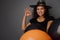 Close-up of beautiful smiling Hispanic woman in wizard hat, dressed in witch carnival costume for Halloween party, shows OK sign,