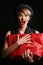 Close up of a beautiful woman with a good sense of humor , holding her fancy red bag.