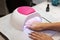 Close-up beautiful woman hands and lamp for nails on table. Nail gel salon.