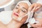 Close-up of a beautiful woman relaxing during facial treatment i