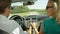 CLOSE UP: Beautiful young couple holding hands while cruising in their car.