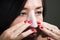 Close up of a beautiful young woman aplying a white nose mask to clean the skin