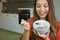 Close up of beautiful young woman eating skyr yougurt with cereal muesli fruit at home, focus on the model eyes, indoor picture.