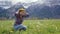 Close up beautiful young woman weaves a wreath of meadow dandelion flowers and tries on herself on mountains background