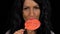 Close-up of beauty brunette girl eating a large lollipop on stick