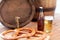 Close up of beer barrel, glass, pretzel and bottle