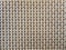 Close-up of beige fabric plastic lattice, grid texture; pattern of horizontal and vertical interwoven lines