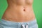 Close up of Belly slim girl in sweat pants on a green background