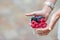 Close up berries fruits at female hands. Blueberries, raspberries, strawberries and blackberries on the market.