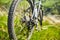 Close-up of the bicycle wheel in the summer green grass in the field.