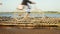 Close-up on bicycles riding and people walking across bamboo bridge/flooring placed over flooded sand along the riverside