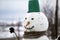 Close-up of big funny primitive smiling snowman head with carrot