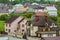 Close-up of big new comfortable two-storied new cottage with green tile roof, big yard, plastic windows and high chimneys in mode