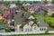 Close-up of big new comfortable two-storied new cottage with green tile roof, big yard, plastic windows and high chimneys in mode