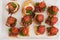 Close-up big plate with serving snack canapes fried bread tomato parsley and salami