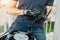 Close up of biker putting on black gloves and sitting on motorcycle