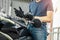 Close up of biker putting on black gloves and sitting on motorcycle