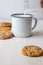 Close-up of biscuit with cup and bottle serving milk, with selective focus, white background,