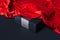 Close up of black blank box under red cloth on black background. 3d rendering.