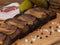 Close-up black bread toasts with bacon on wooden background with garlic, salt and spices