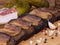 Close-up black bread toasts with bacon on wooden background with garlic, salt and spices