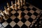 Close up of black chess pieces on board. Two rows of wooden figures on chessboard on black background. Concept of