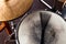 Close-up of of black drum brush on a white shabby drum and Ð° part of golden cymbal. Concept concert, live music, performance,