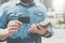 Close-up of black empty credit, business, calling, visiting card in hand of young businessman, standing outdoors.