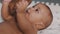 Close up black father tickling tummy of his newborn baby . Fatherhood and multiracial family