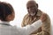 Close up of black female doctor holding male patient's hands