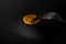 Close-up Black food plate, with fork and spoon, and golden bitcoin on black background