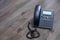 Close Up Black ip phone is placed on a wooden floor in the office