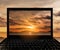 Close-up Black Laptop with landscape sunset at tropical ocean island on screen