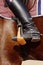 Close up black leather riding boots in stirrups on brown horse, copy space. Equestrian sport.