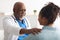 Close up of black male doctor tapping patting patient's shoulder