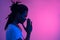 Close up of black man with dreadlocks praying on purple background