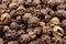 Close up of black peppercorn on pile of peppercorns