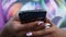 Close-up of black phone in hands of african woman