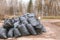 Close-up of black trash bags piled up In the city park.