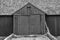 Close up of a black an white barn with large double doors.