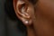 Close up of black woman ear wearing shiny diamond earrings