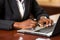 Close-up. Black Womans Hands Typing on Laptop in a Brightly Colored Modern Office Setting