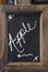 Close-up of blackboard with word `Apple` written on it with an arrow showing to the left, fixed in a wooden rustic frame