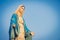 Close-up of the blessed Virgin Mary statue figure. Catholic praying for our lady - The Virgin Mary. Blue sky copy space on